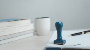 Paperwork on a clipboard with a rubber stamp on top
